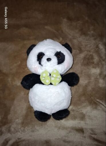 oyuncaq ayi: Ağ və qara rənglərdə yumşaq panda oyuncağı. Oyuncağın boynunda yaşıl