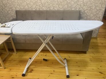 paltar aslqanı: Ağ rəngli, qatlanan dayaqları olan metal ütü masası. Rahat ütüləmə