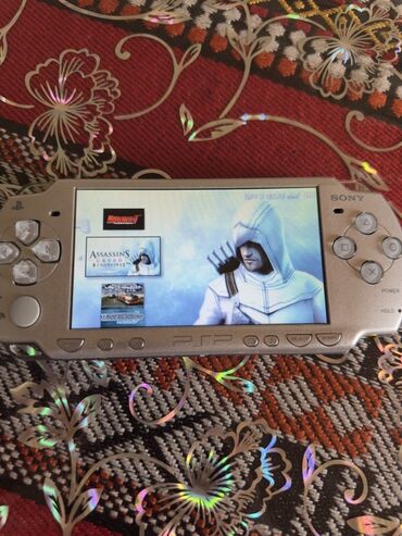 psp adapter: Gümüşü rəngdə olan Sony PSP əl oyun konsolu. Əziyi cızığı yoxdur