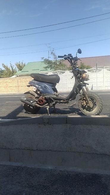 Скутер 150 куб. см (наклейка “NEW 49” на облицовке). Компактный
