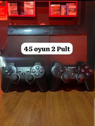 PS3 (Sony PlayStation 3): Qara rəngdə olan Sony PlayStation 3 oyun konsolu, iki ədəd Sony
