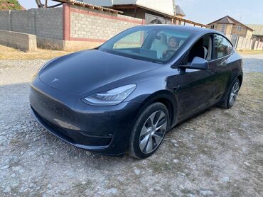 электромобили из китая: Электрический кроссовер Tesla Model Y в темно-сером цвете, оснащенный