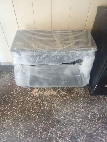 Dinamiklər və kolonkalar: Şəffaf qablaşdırma materialına bükülmüş qara rəngli düzbucaqlı dinamik