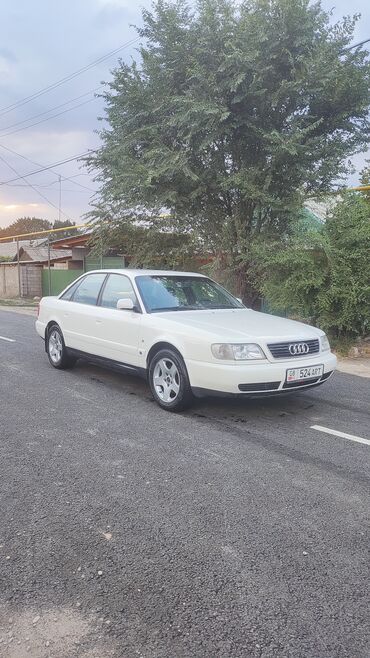 экран на машину: Белый седан Audi, модель A6, оснащен стандартными колесными дисками и