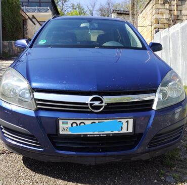 Opel: Göy rəngdə olan Opel Astra universal avtomobili. Geniş salonu və