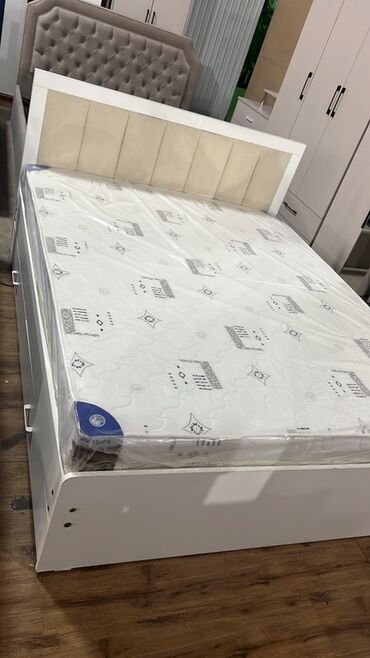 Двуспальные кровати: Кровать с мягким изголовьем, обтянутым светлой тканью, и белым