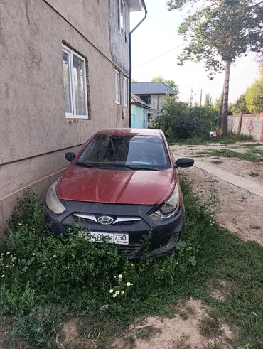 купить запчасти на опель вектра б: Красный седан Hyundai с черным бампером, расположенный у стены здания