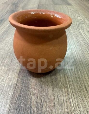 Terracotta rəngində, dəyirmi formalı, kiçik ölçülü saxsı qab. Bitki