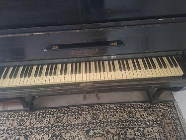 piano az: Qara rəngli, klassik üslubda akustik pianino. Korpus üzərində — 2