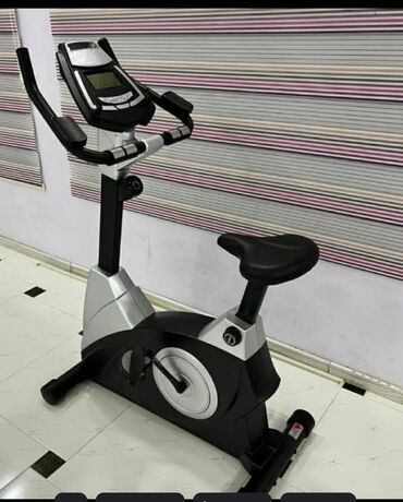 Elliptik trenajorlar: Qara və gümüşü rəngdə olan stasionar velosiped trenajoru. LCD ekranı