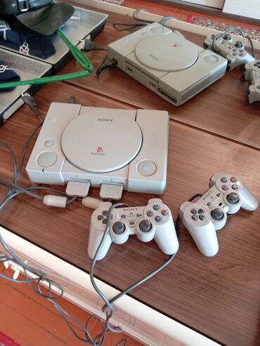 2 ci əl soyuducular: İki ədəd Sony PlayStation oyun konsolu. Konsollar standart boz