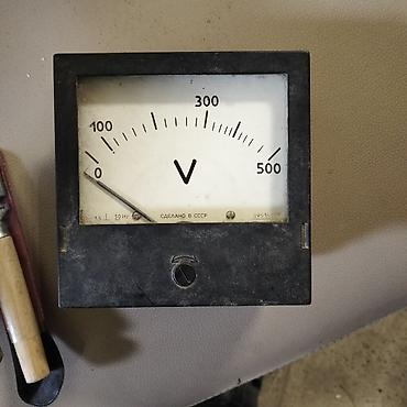 Panel tipli analoq voltmetr. Göstərici üzərində “V” işarəsi var və