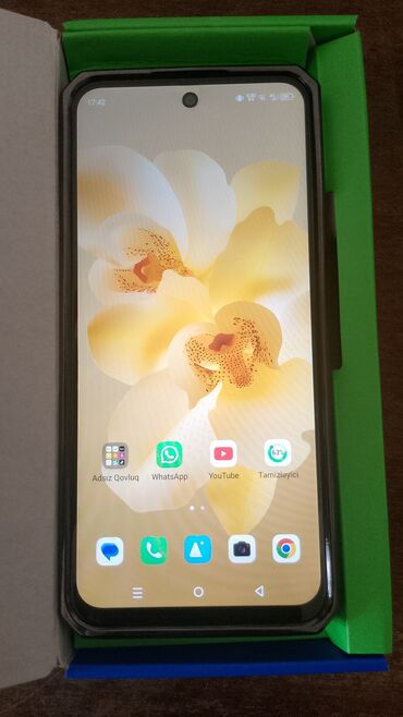 Чайники: Ekranında canlı sarı orxideya fonu olan qara rəngli smartfon. Cihazın