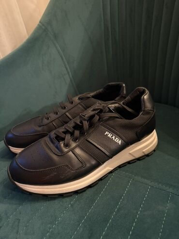 Krasofkalar və idman ayaqqabıları: Qara rəngdə, dəri elementləri olan Prada idman ayaqqabıları. Yüngül və