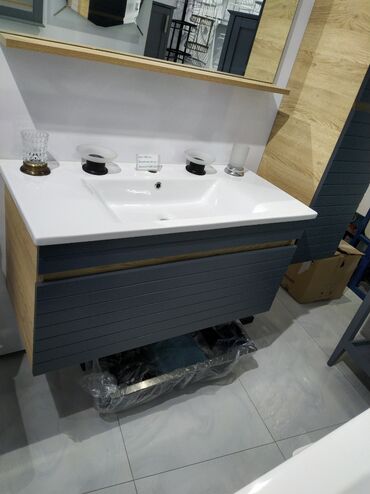 Qapılar və aksessuarlar: Ağ rəngli keramika lavabo və boz rəngli taxta dolabdan ibarət hamam