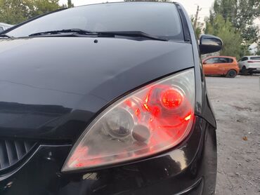 мини электромобиль: Черный хэтчбек Mitsubishi Colt с красной подсветкой фар. Автомобиль