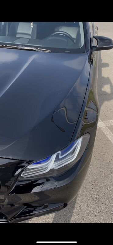 BMW: Qara rəngli, müasir dizaynlı avtomobilin ön hissəsi. Faralar LED
