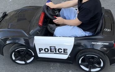 Uşaq üçün elektrik maşınları: Qara və ağ rənglərdə, polis dizaynlı uşaq elektrik avtomobili. "FAST