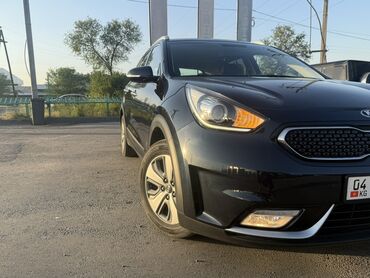 Kia: Автомобиль Kia Niro, выполненный в черном цвете, представляет собой