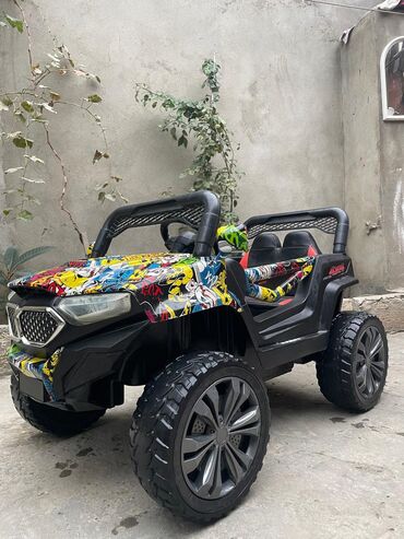 polis masini usaq ucun: Qara rəngli, üzərində müxtəlif rəngli naxışlar olan uşaq elektrik