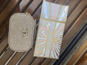 Qızılı rəngdə parıltılı qadın çantası və Christian Dior temalı