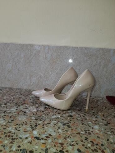 Çəkmələr: Nude rəngdə, incə uclu, stiletto dabanlı qadın ayaqqabıları. Klassik