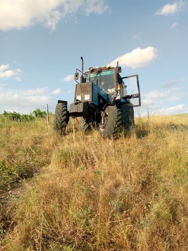 запчасти мтз 82 передний мост: Mavi rəngli, iri təkərli traktor sahələrdə və kənd təsərrüfatı