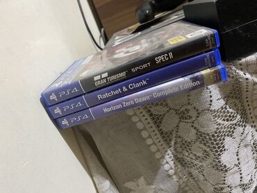 PlayStation 4 oyun konsolu və ona aid üç disk. Konsol stikerlərlə