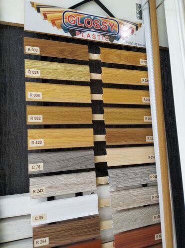 Laminat: Müxtəlif rəng və naxışlarda parlaq plastik plintus nümunələri. Hər bir