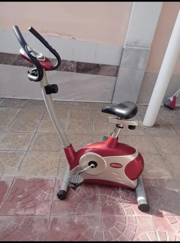 Velotrenajorlar: Qırmızı və gümüşü rənglərdə olan velosiped trenajoru. Üzərindəki ekran