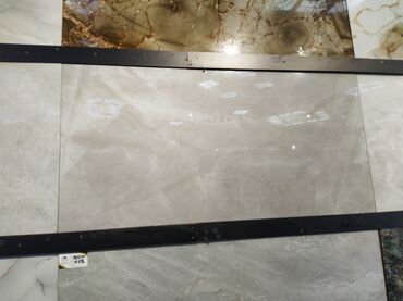 kreditle kafel metlax: Bej rəngli, damarlı dizaynı olan keramika plitəsi. Hamam, mətbəx və ya