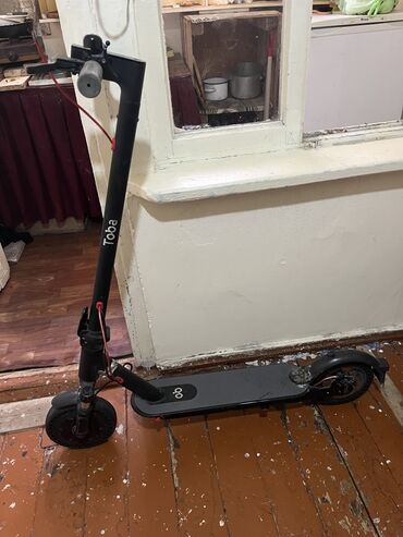 Toba markalı, qara rəngli elektrik skuter. Bu modeldə sağ tərəfdə