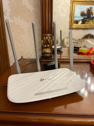 sim modem wifi: Ağ rəngdə olan TP-Link şirkətinin simsiz marşrutizatoru. Dörd ədəd
