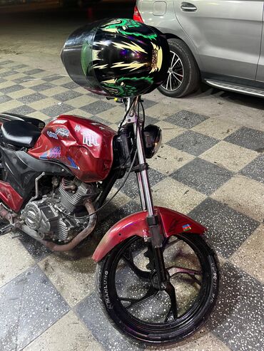 Motosikletlər: Fərqli qırmızı rəngdə motosiklet. Qara rəngli oturacaq və bir cüt yan