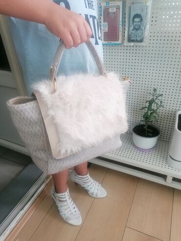 Torbe: Ženska torba sa preklopom od veštačkog krzna u bež boji. Torba ima dve — 1