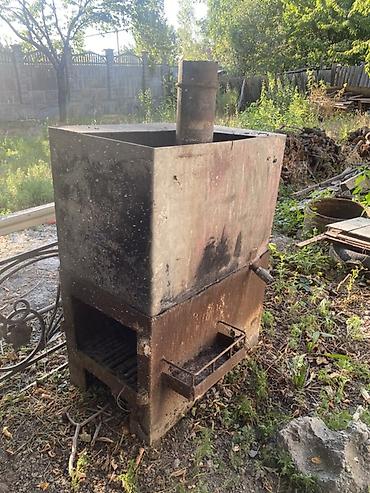 Металлическая дровяная печь с баком и дымоходом. Конструкция