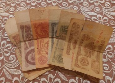 стоимость старых бумажных денег: Şəkildə müxtəlif dövrlərə aid, köhnəlmiş və zamanın izlərini daşıyan