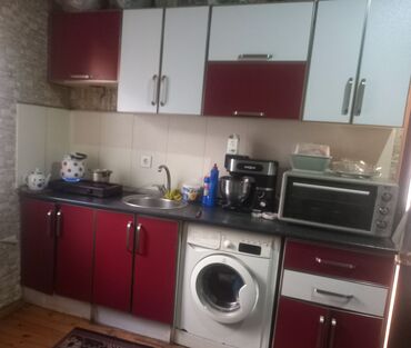 Mətbəx mebeli: Mətbəx mebeli dəsti. Üst şkaflar ağ və qırmızı rəngdədir. Aşağı