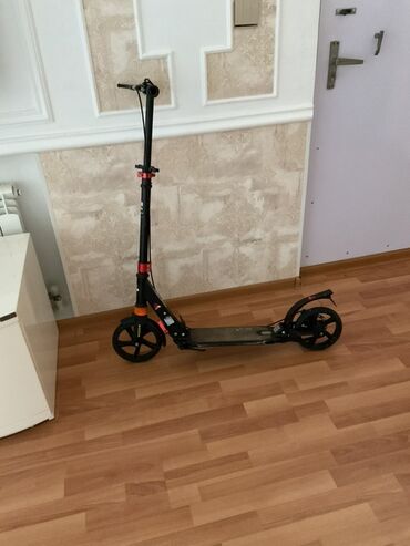 informatika 2 ci sinif derslik: Qara rəngli, təkərli skuter. Bu skuter, yığcam dizaynı sayəsində