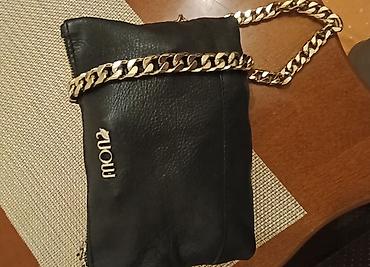 guess privezak: Crna ženska tašna sa metalnim lancem u srebrnoj boji. Model je — 2