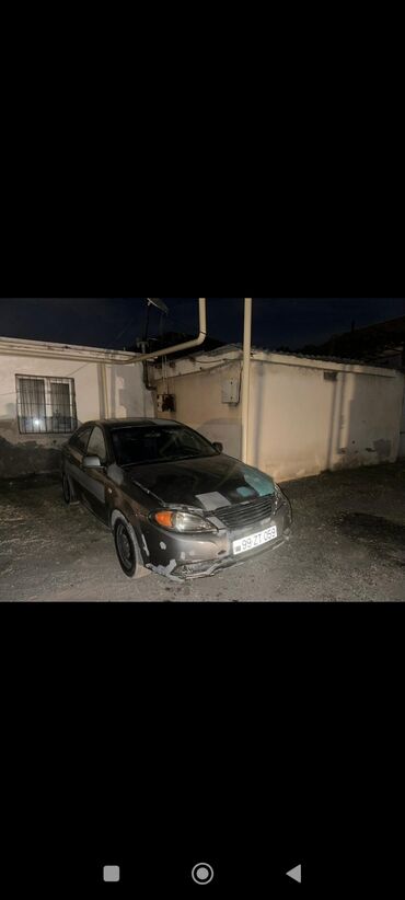 авто в кредит: Ön tərəfində yüngül zədələri olan tünd rəngli Daewoo Gentra sedan