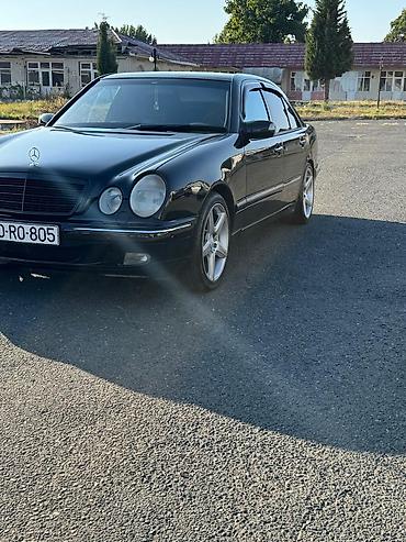 w210 panel: Mercedes‑Benz E‑Class (W210) sedan, qara rəng, tünd plyonka ilə — 1