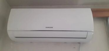 optimal kondisioner: Divara quraşdırılan ağ rəngli "Samsung" kondisioner. İstilik və
