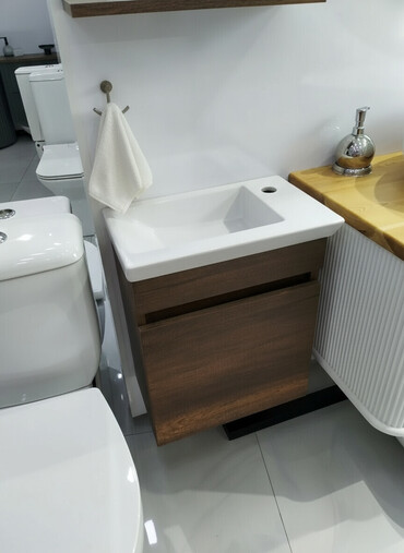 taxta atma: Ağ rəngli keramika lavabo və qəhvəyi rəngli taxta dolabdan ibarət bu