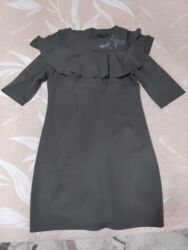 qaqa geyimi: Qadın paltarı – tünd yaşıl rəngdə, dizə yaxın uzunluqda, düz kəsimli