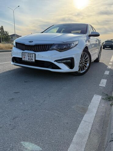 киа optima: Автомобиль Kia Optima белого цвета с люком на крыше. Эта модель