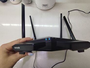 Kompüter ehtiyyat hissələri: Dörd antenalı "Tenda" markalı qara rəngli router. Bu router etibarlı