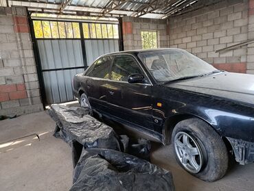 коллектор выпускной: Audi 100 C4, седан, черный цвет. Автомобиль в гараже, на фото видны