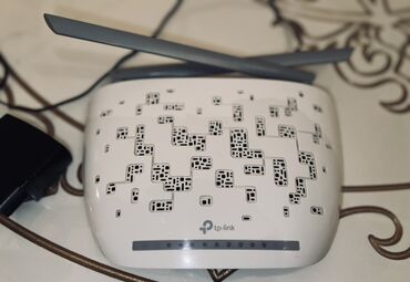Комплектующие для ПК и ноутбуков: TP-Link markalı ağ rəngli simsiz router. Cihazın üst hissəsində qara