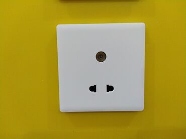 Generatorlar: Ağ rəngli, kvadrat formalı divara quraşdırılan elektrik rozetkası və